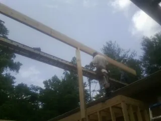 Carpenter setting a ridge beam over a new addition frame — Ice Dam Removal by Roofing Brothers in Huntingburg