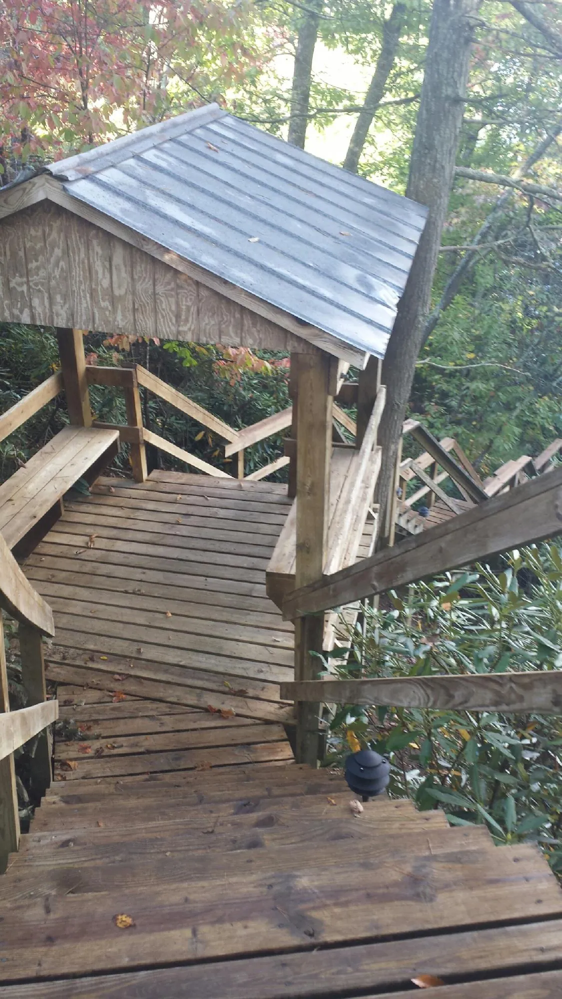 Metal roofed shelter over wooden steps on a wooded walkway — Skylight Repair & Installation work by our crew in Huntingburg